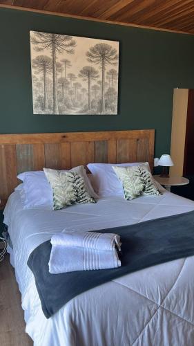 a bedroom with two beds and a picture on the wall at Pousada Casa Pinha em Campos do Jordão in Campos do Jordão