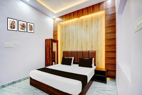 una camera da letto con un letto e una parete di legno di HOTEL O JANKI Kalyanpur Railway Station a Kānpur