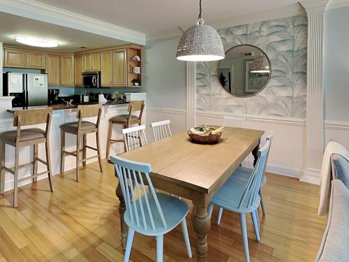 a kitchen and dining room with a wooden table and chairs at Brass Rail 318 in Tybee Island