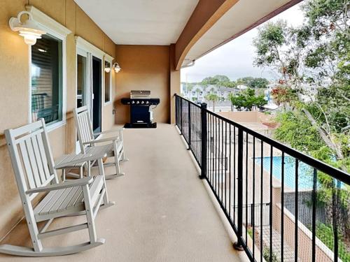 a balcony with two chairs and a grill at Brass Rail 318 in Tybee Island