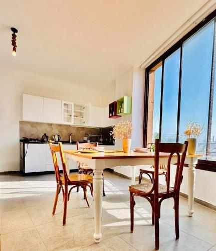 a kitchen with a table and chairs in a room at La Luna Luz 1BR Apt w Balcony by the Bahsa Sea in Batroûn