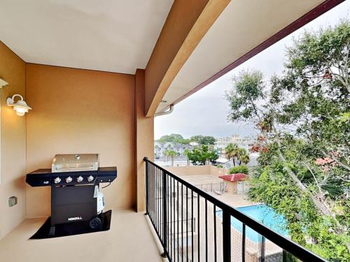 a balcony with a grill and a swimming pool at Brass Rail 318 in Tybee Island