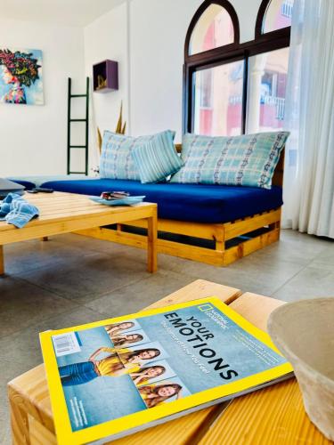 a living room with a blue couch and a magazine at La Luna Luz 1BR Apt w Balcony by the Bahsa Sea in Batroûn