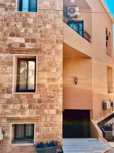a facade of a building with a brick wall at La Luna Luz 1BR Apt w Balcony by the Bahsa Sea in Batroûn