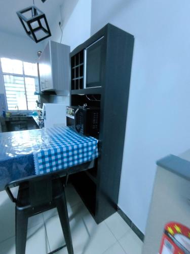 a kitchen with a desk with a microwave and a table at Homestay Annur Impian Temerloh With WIFI & NEXFLIX in Temerloh