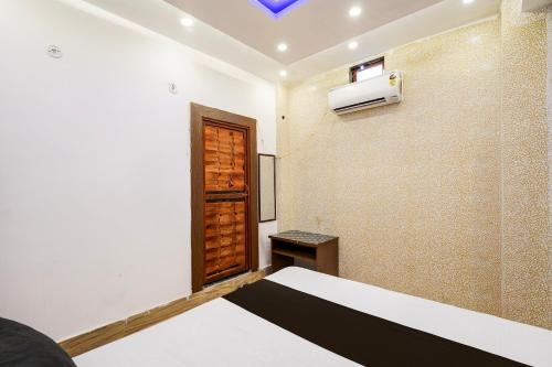 a bedroom with a bed and a tv on the wall at Hotel O JS Palace in Gorakhpur