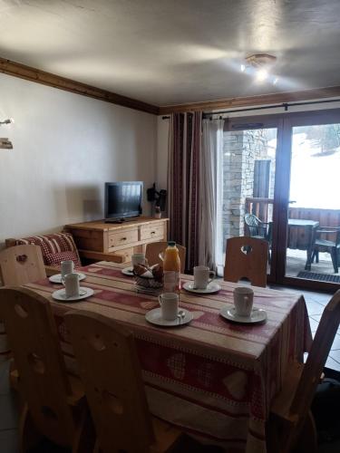 un tavolo da pranzo con tazze e piattini sopra di Critérium 01 a Lanslebourg-Mont-Cenis