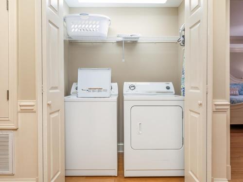 a kitchen with a stove and a washer and dryer at Brass Rail 317 in Tybee Island