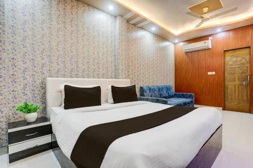 a bedroom with a bed and a blue chair at Townhouse OAK R R Palace in Varanasi