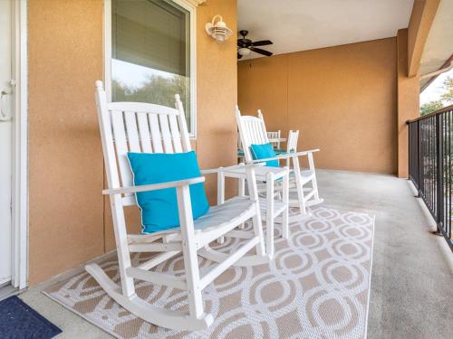 three rocking chairs sitting on a porch at Brass Rail 317 in Tybee Island