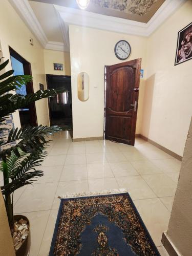 a hallway with a door and a clock on the wall at Studio Meublé tres accessible avec tout les commodités au environs in Dakar