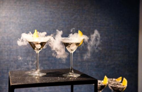 two martini glasses with smoke on a table at NYX Hotel Mannheim by Leonardo Hotels in Mannheim