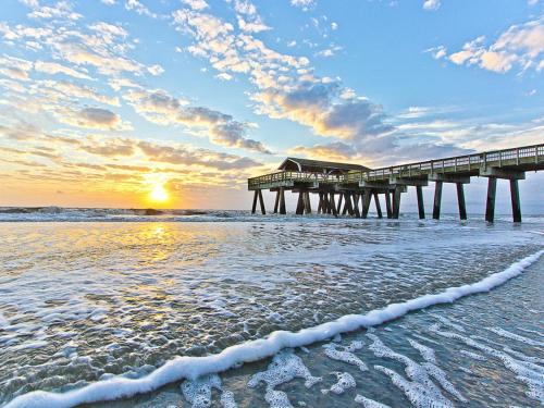 a pier on the beach with the ocean at Brass Rail 315 in Tybee Island
