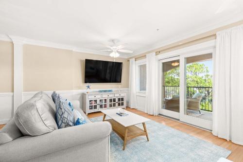 a living room with a couch and a tv at Brass Rail 315 in Tybee Island