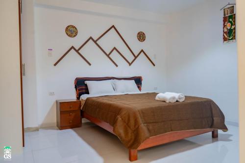 ein Schlafzimmer mit einem großen Bett mit einer braunen Decke in der Unterkunft GS Hoteles-Cajamarca in Cajamarca