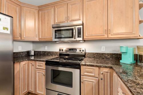 a kitchen with wooden cabinets and stainless steel appliances at Brass Rail 315 in Tybee Island
