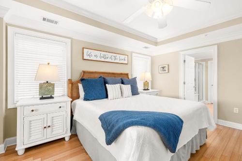 a bedroom with a large bed with blue pillows at Brass Rail 315 in Tybee Island