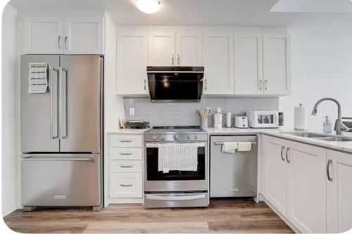 a kitchen with white cabinets and stainless steel appliances at Bright Queen Room with Shared Bathroom near Downsview Park Subway York University and Yorkdale Mall in Toronto