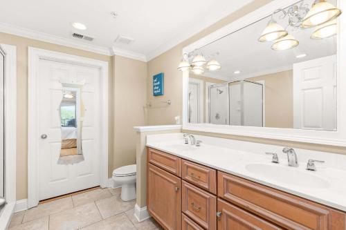 a bathroom with a sink and a toilet and a mirror at Brass Rail 315 in Tybee Island