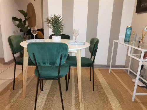 a table with green chairs and a table with wine glasses at The Centurion Sunset in Centurion