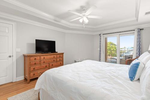 a bedroom with a bed and a television on a dresser at Brass Rail 220 in Tybee Island