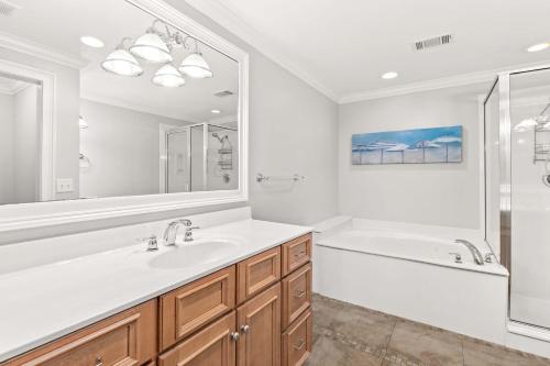 a white bathroom with a tub and a sink and a shower at Brass Rail 220 in Tybee Island