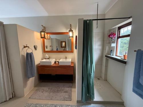 ein Badezimmer mit Waschbecken und Spiegel in der Unterkunft Rosemarys Cottage in Koringberg