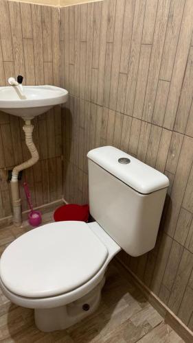 a bathroom with a white toilet and a sink at Casa Mobiliada com 4 camas e 2 quartos in Juazeiro do Norte