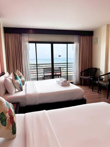 a hotel room with two beds and a balcony at Grand Jomtien Palace Hotel - SHA Extra Plus in Jomtien Beach