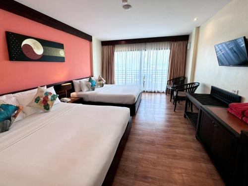 a hotel room with two beds and a red wall at Grand Jomtien Palace Hotel - SHA Extra Plus in Jomtien Beach