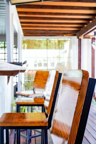 a row of wooden chairs sitting on a porch at Corten Villa - A Vacation within Your Vacation in Saint Georgeʼs