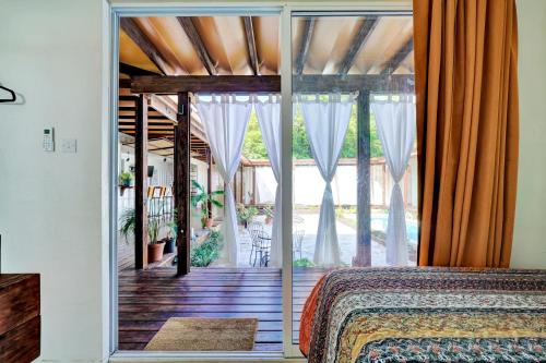 a bedroom with a bed and a sliding glass door at Corten Villa - A Vacation within Your Vacation in Saint Georgeʼs