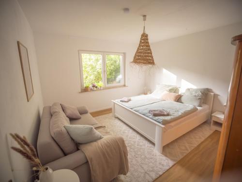 a living room with a bed and a couch at 70er Bungalow in Farven