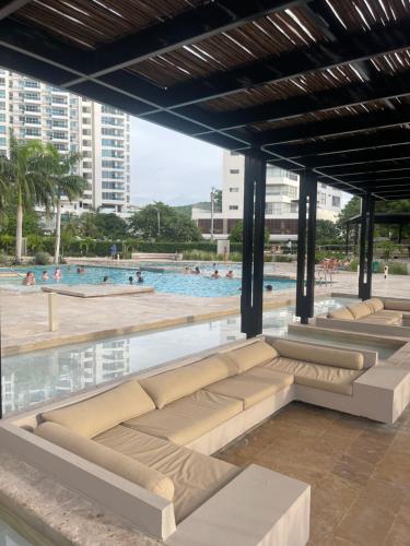 a row of benches in front of a swimming pool at Apartamento Santa Marta Reserva del Mar 530 in Gaira