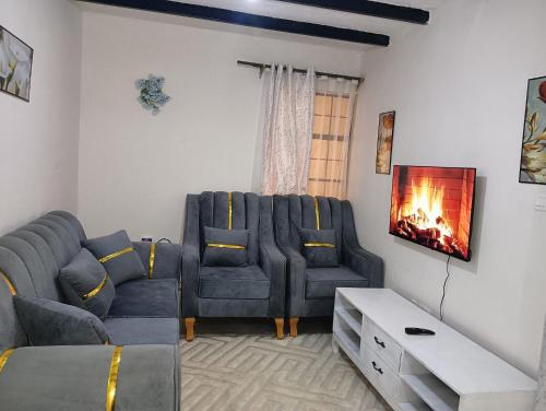 een woonkamer met een bank en een tv bij Cozy Homes Kitengela in Nairobi