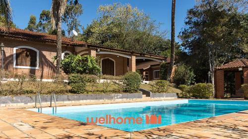 una piscina frente a una casa en Chacara em Monte Sião com Piscina e Lazer Completo, en Monte Sião