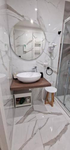a white bathroom with a sink and a mirror at La Corte dei Sarti in Copertino