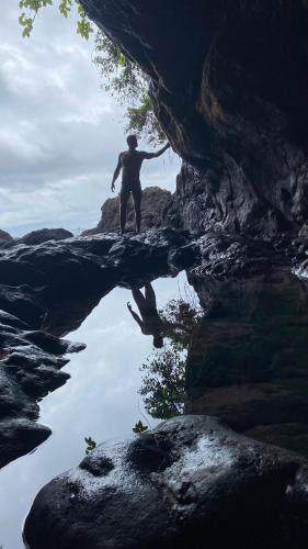 a man standing on a rock in a cave at Hostal La Esmeralda in El Valle