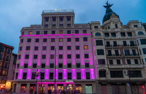 a building with purple lights on the front of it at NYX Hotel Bilbao by Leonardo Hotels in Bilbao