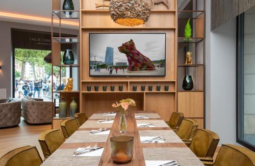 a long table in a restaurant with a picture of a dog at NYX Hotel Bilbao by Leonardo Hotels in Bilbao