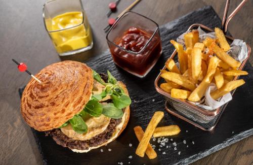 a sandwich and french fries on a black tray at NYX Hotel Bilbao by Leonardo Hotels in Bilbao