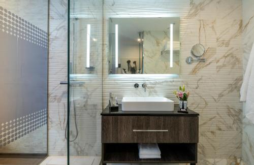 a bathroom with a sink and a mirror at NYX Hotel Bilbao by Leonardo Hotels in Bilbao