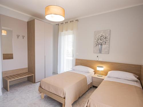 a bedroom with two beds and a window at Casa Bellavista in SantʼAntonio Abate