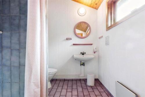 a bathroom with a sink and a toilet and a mirror at 4720-Ronne-Stampen-Vej-2-Hus-18 in Rønne