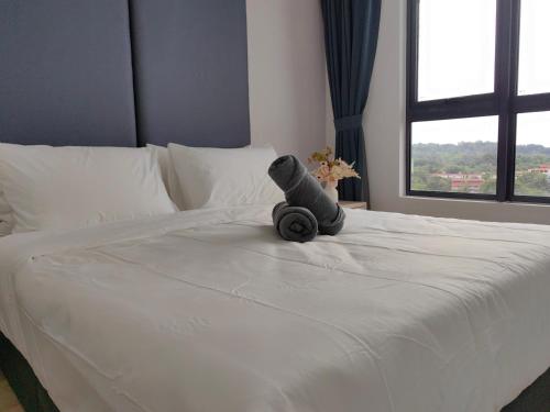 a teddy bear sitting on top of a bed at Vetro11 Beside QEH1 by JUNE Homestay in Kota Kinabalu