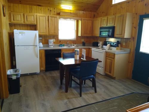 a kitchen with a table and a white refrigerator at Urban Escape - 1BR King Cabin in Gatlinburg
