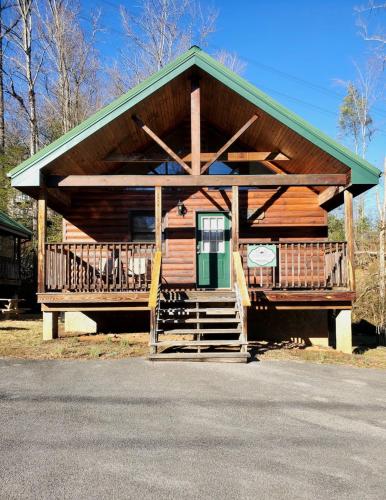a large wooden cabin with a green roof at Urban Escape - 1BR King Cabin in Gatlinburg