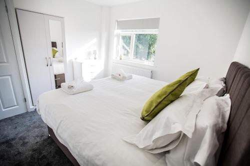 a white bed with a green pillow on it at Halford House 3 Bed Town Centre Home from Home with Parking for 2 cars Prime Location Tamworth in Tamworth