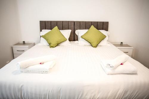 a large white bed with two towels on it at Halford House 3 Bed Town Centre Home from Home with Parking for 2 cars Prime Location Tamworth in Tamworth