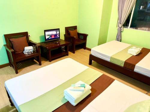 a hotel room with two beds and a television at Albergo Hotel - Studio Condo Unit - Baguio Transient in Baguio